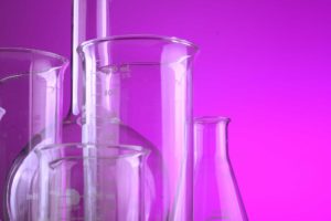 scientific glassware pink purple background